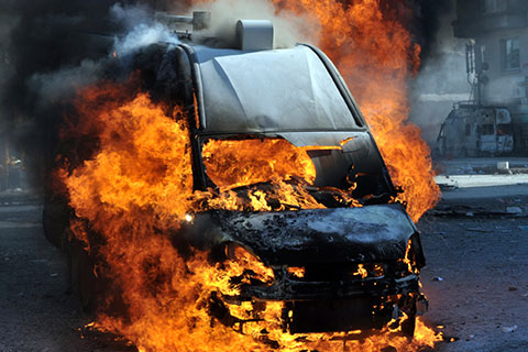 a black van explodes into flames in the street